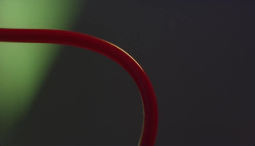 A curved plastic tube with bubbles on the inside quickly fills with red liquid