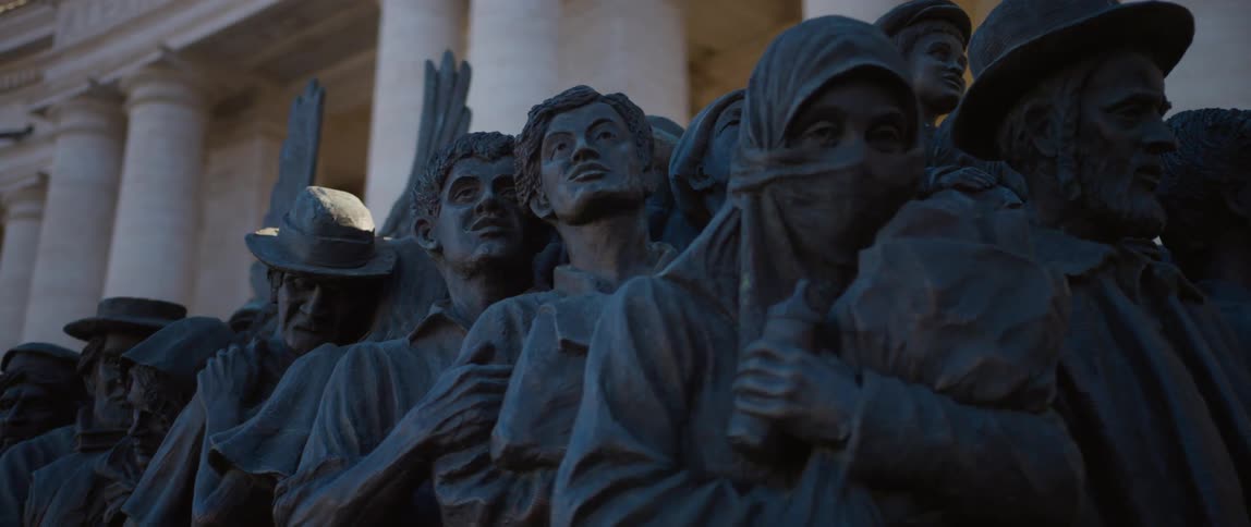 A statue of people of people in front of a pillared building