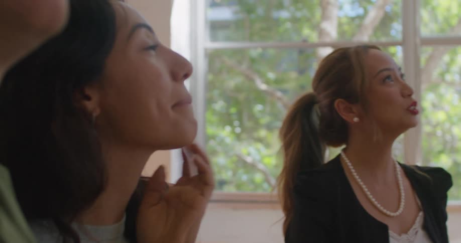 Three people standing around inside talking
