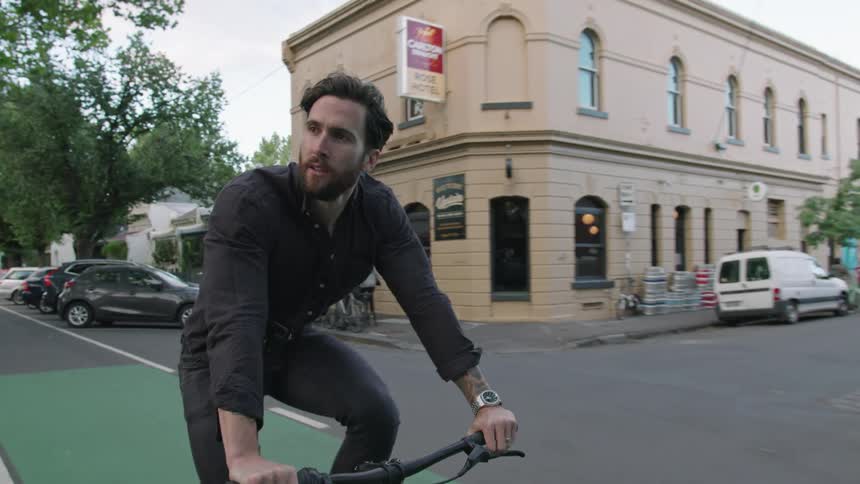 A man is riding his bicycle through town