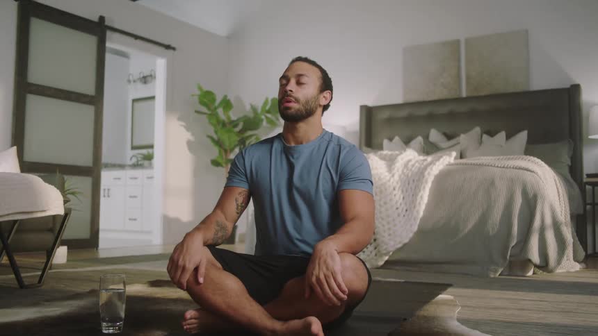 A man meditating on the floor of a room
