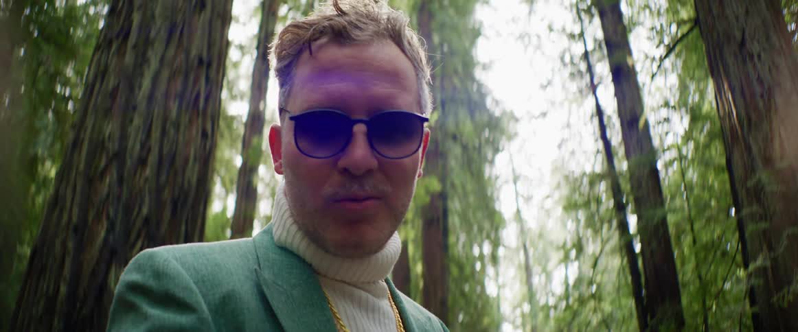 A man is posing outdoors in a forest in spring