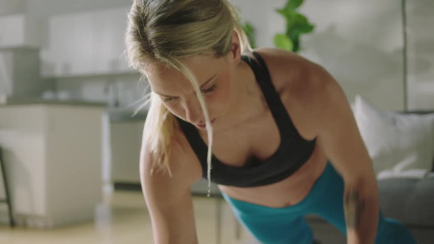 A man and woman work out at home