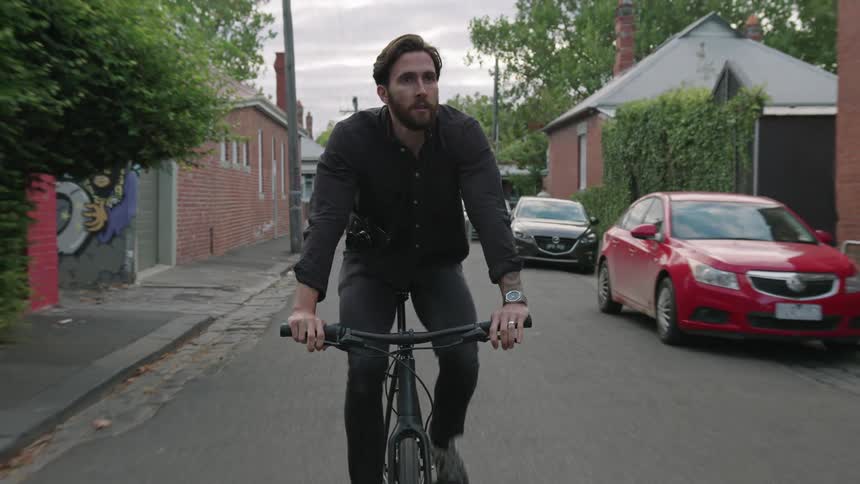 A man riding his bike down a road