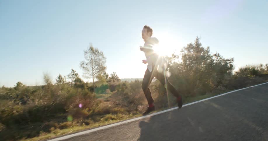 A man is running on the road at sunrise