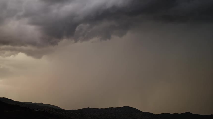 Lighting flashes through dark dense clouds in the sky