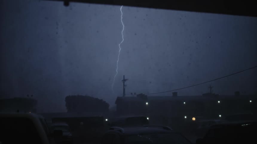 A storm with lightning is forming in a small town