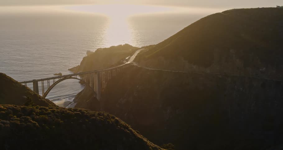Aerial view of a bridge near the mountains at dusk