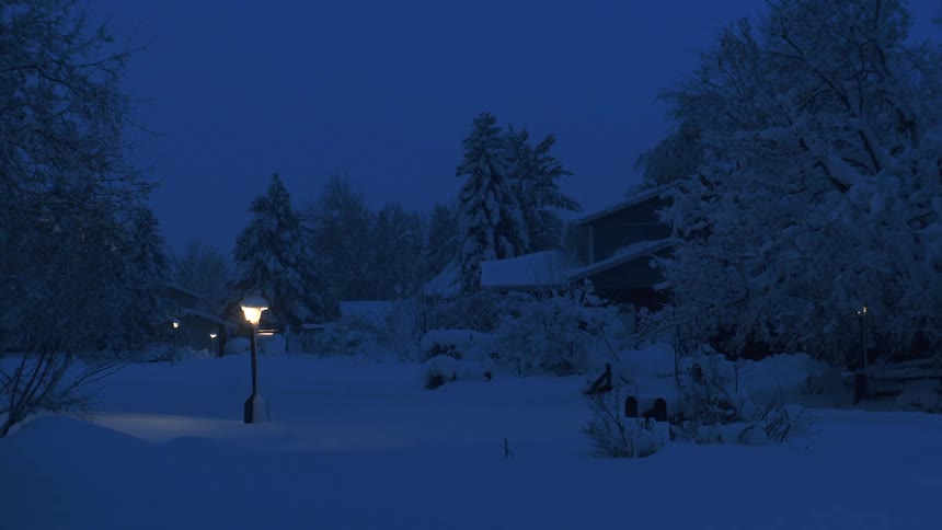 A street lamp glowing in a neighborhood on a cold winter night