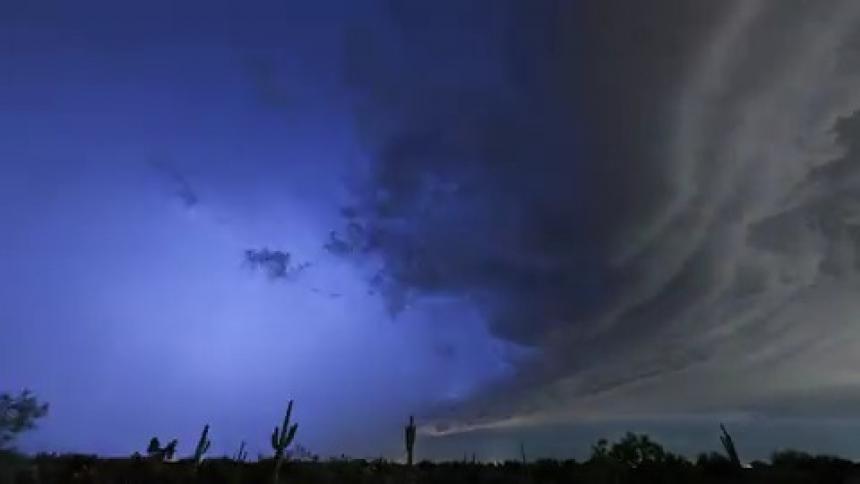 The storm clouds flash with lightning