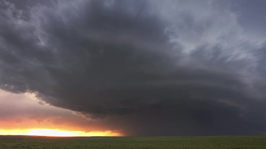 Dark clouds move over a field as lightning strikes during a storm