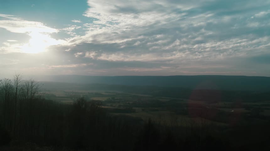 A view of a grassy landscape is displayed at dusk