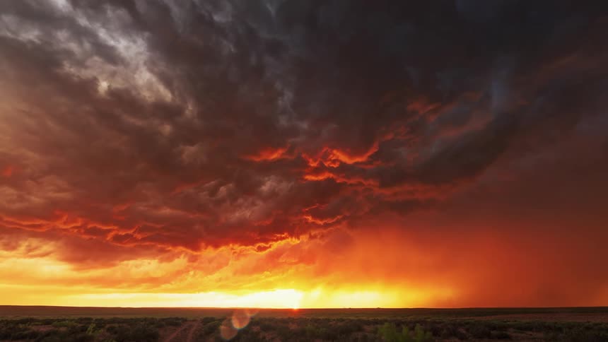 Dark clouds move over a field as lightning strikes