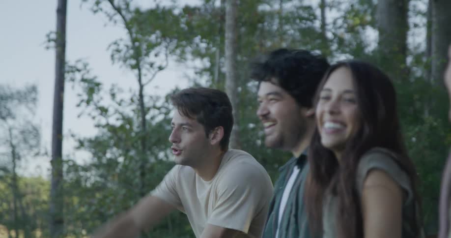 A group of four friends are outdoors in a wooded area