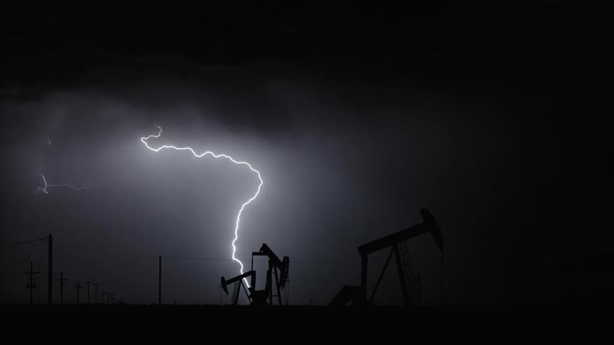 Lightning strikes in the sky seen from oil field