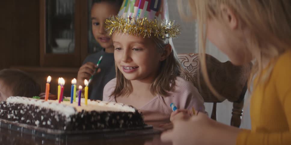 A child blowing out candles on a cake