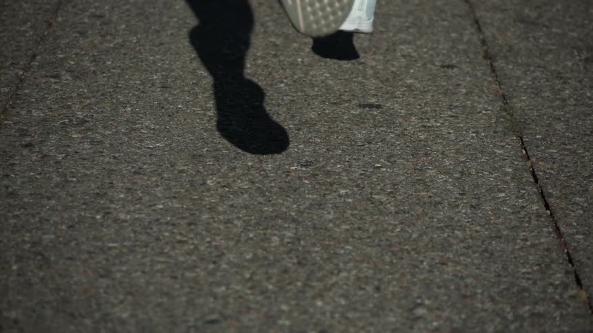 A person is jogging on the sidewalk
