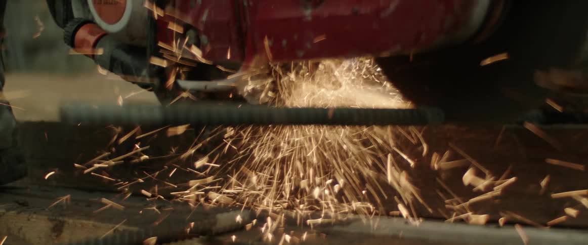A person is cutting a rebar with a tool