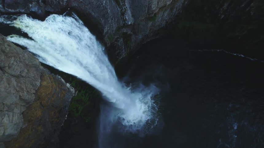 Waterfall flows down stone cliff into pool