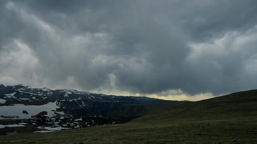 Stormy clouds are above the landscape at dusk