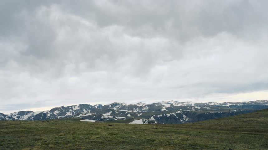 Dark clouds move over snow covered mountains
