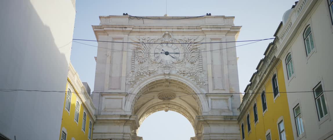 Clock with roman numerals at the top of an arched building