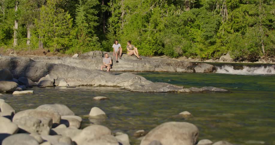 A group of people hanging out next to a lake