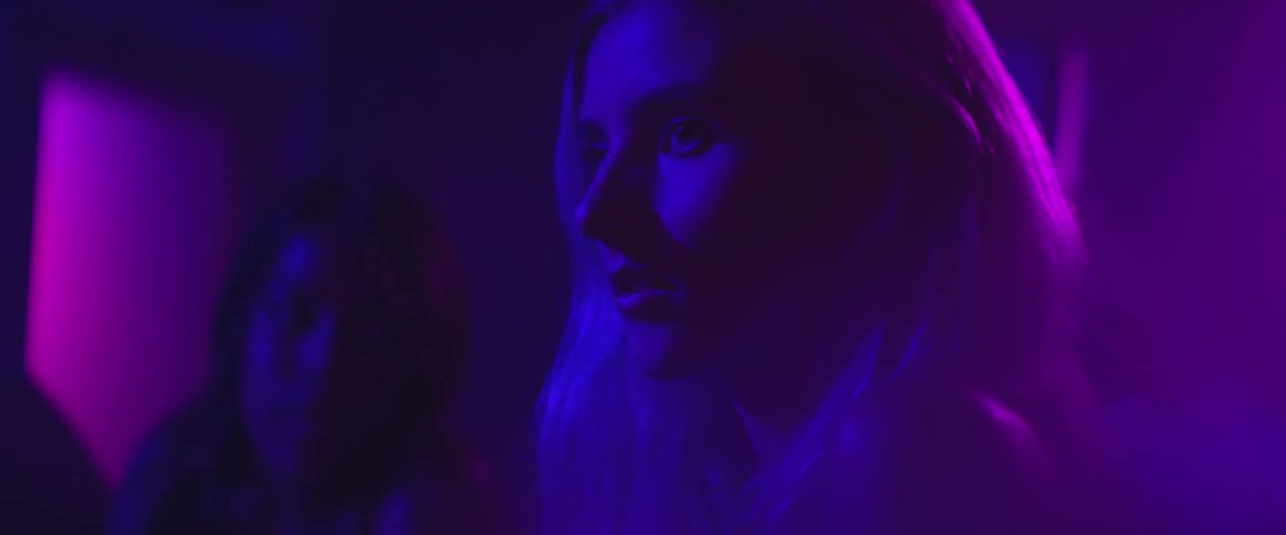 Blonde woman under purple and blue lighting