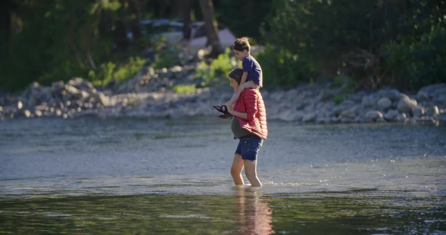 A mother is carrying her son on the water coast
