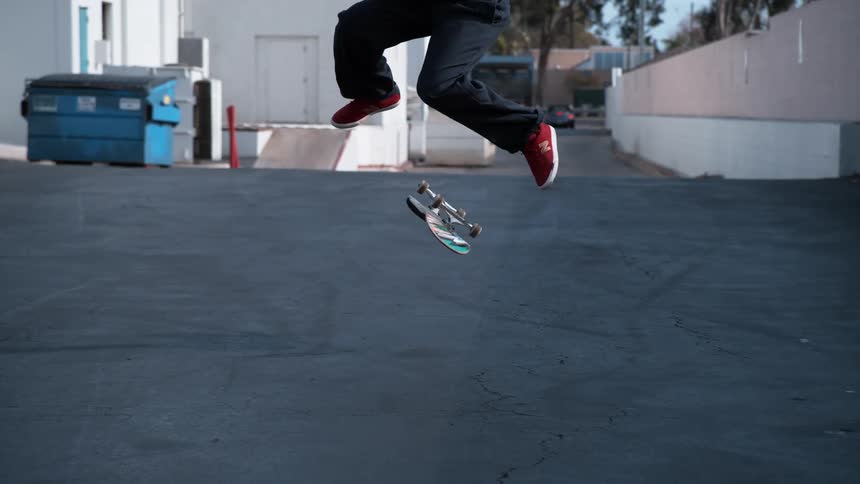 A man is skateboarding in a parking lot during spring