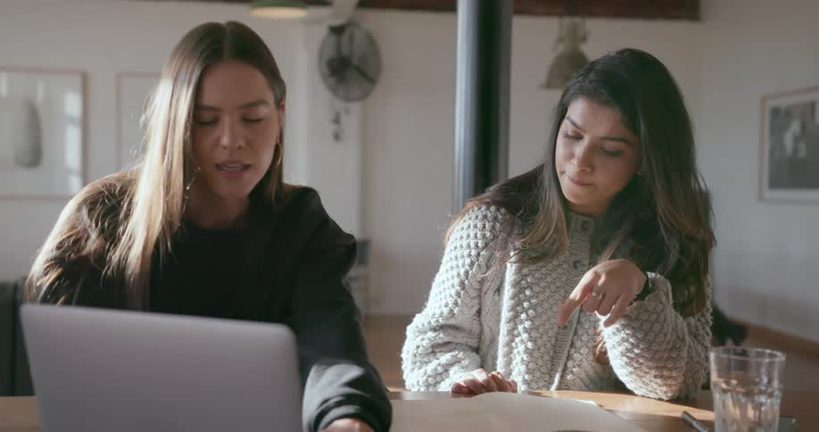 Two women have a conversation at a kitchen counter