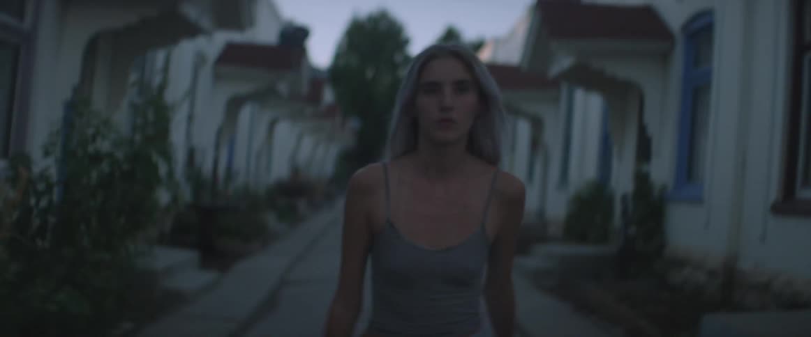 Woman briskly walking between rows of houses