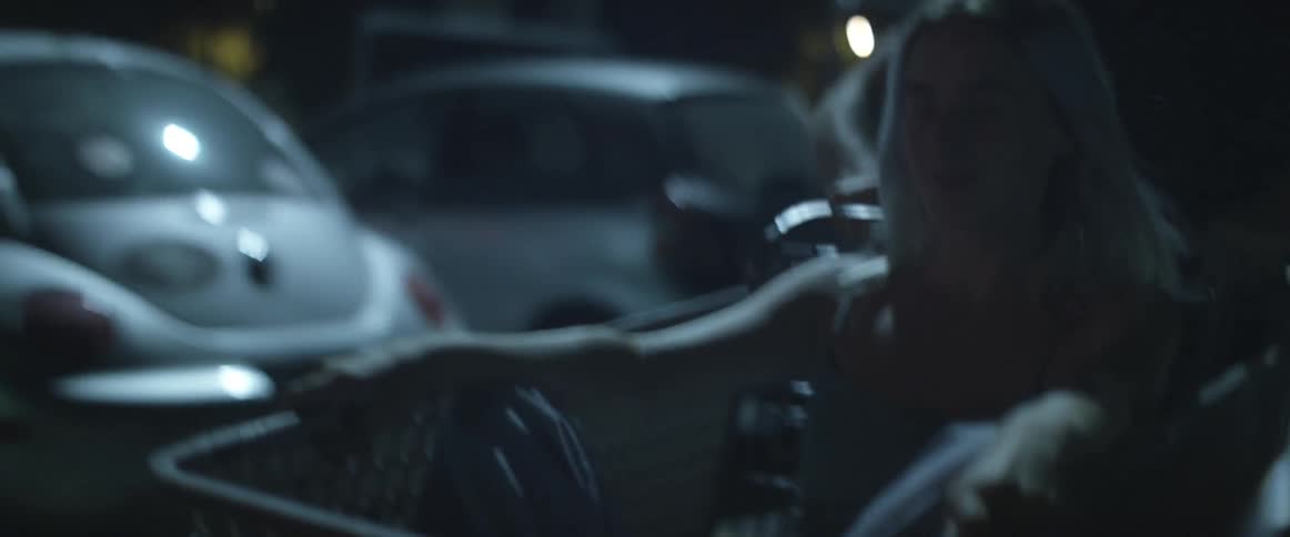 A man is pushing a woman in a cart at night