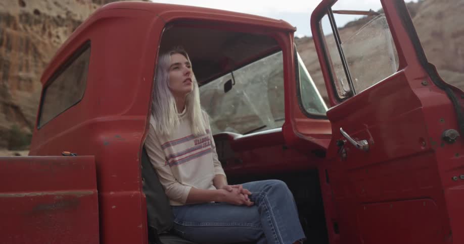 A woman is sitting in a red truck