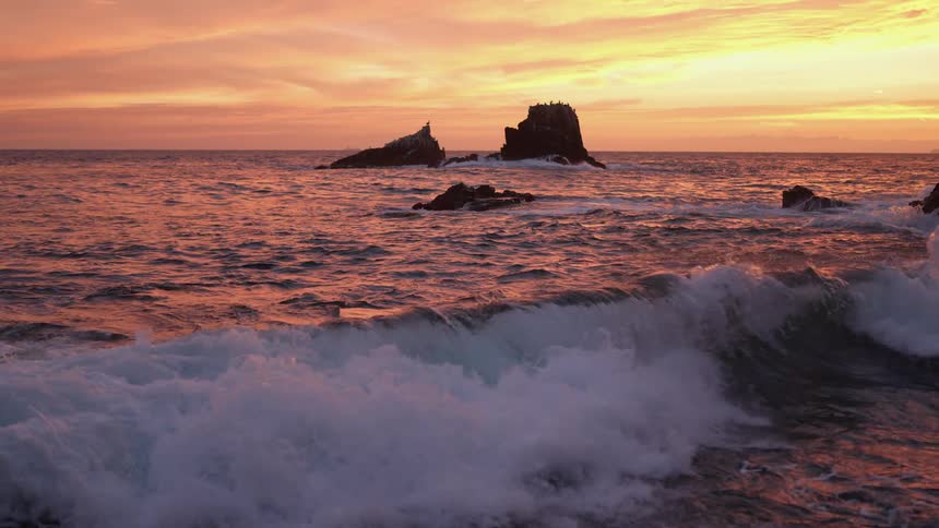 Ocean waves roll in to shore at sunrise