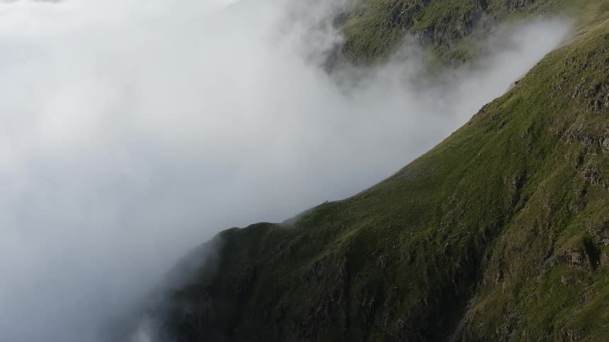 The clouds flow over the mountain