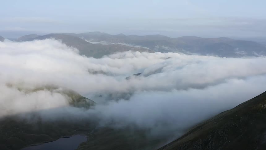 Dense clouds fill the valley between mountains