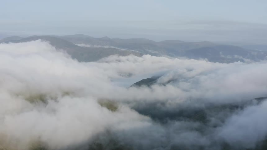 Thick clouds move between mountains