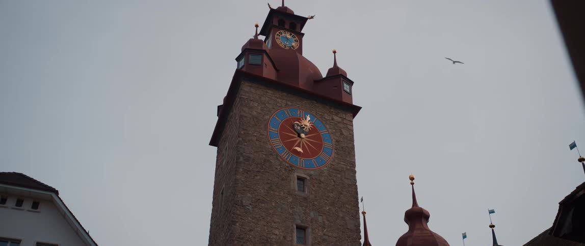 A clock tower with a colorful clock face in the evening