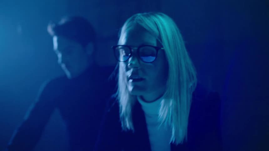 Two people are in a room and looking at something