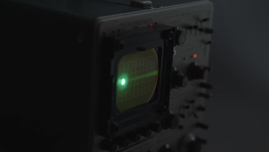 A neon green line moves rapidly across a small screen on a piece of equipment