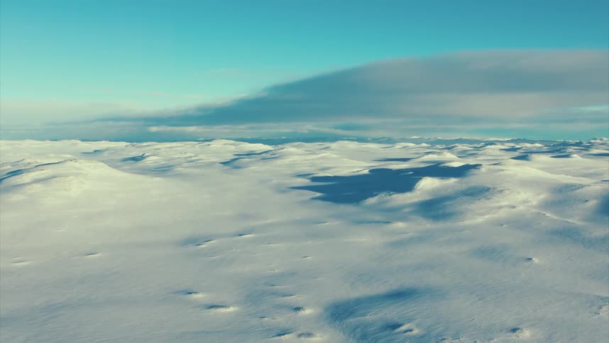Aerial view of snowy field and ice dunes