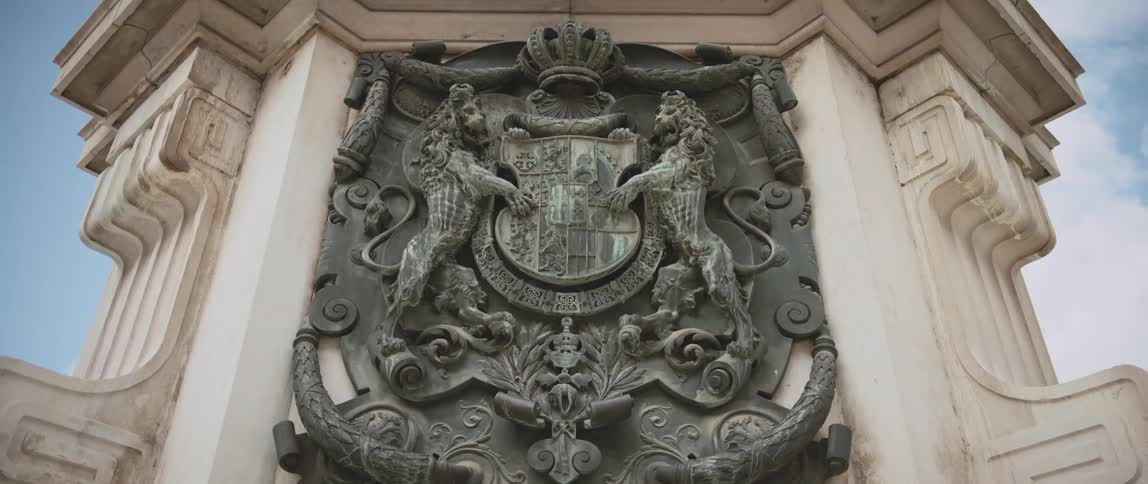 A sculpted crest on a monument outdoors during the day