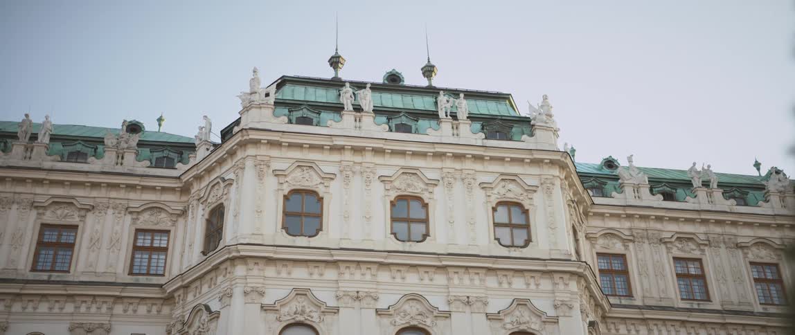 A large building with an elaborately sculpted facade under a clear blue sky