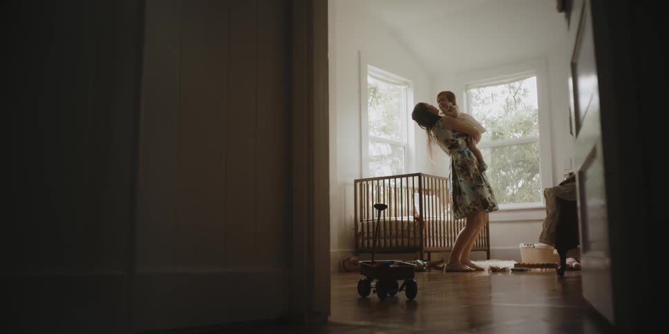 A woman picks up a baby and holds her