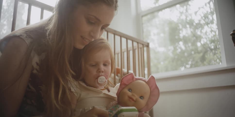 A woman sits with her baby by the window