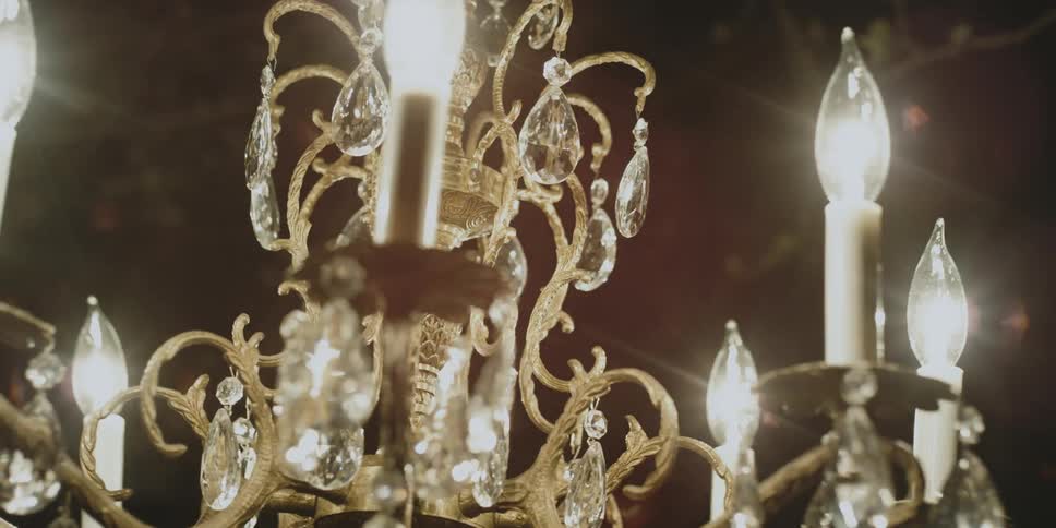 The crystals on a lit chandelier shine