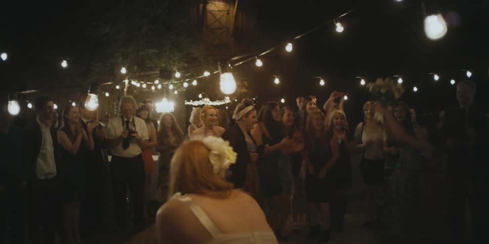 A woman tosses the flowers behind her at a wedding