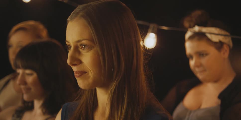 A woman starts to tear up at a wedding