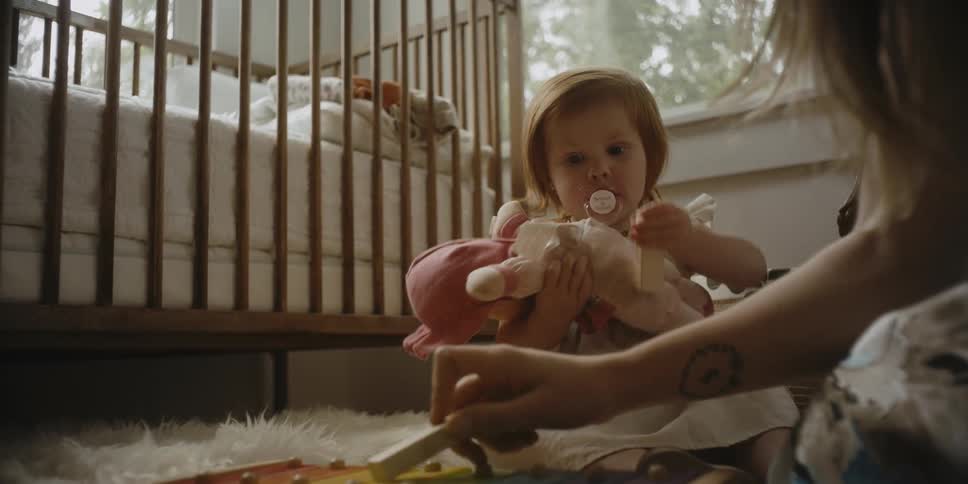 A woman is playing with toys with her baby